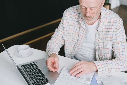 person working remotely on a laptop with bills